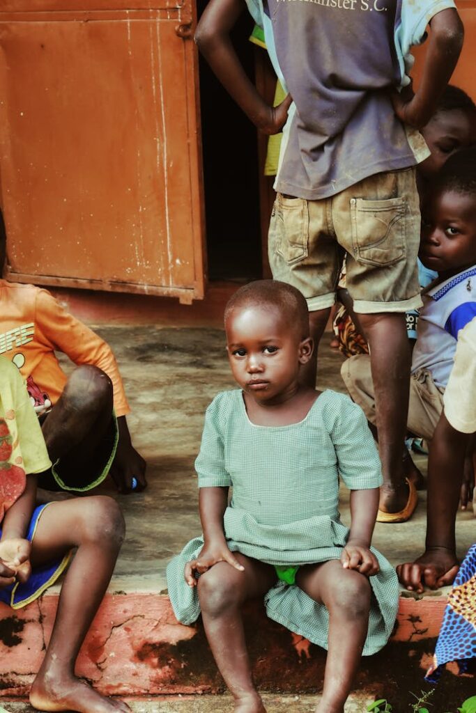 Group of children sitting on a porch, evoking community spirit.